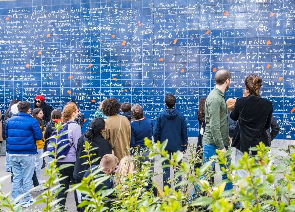 Tourists gathered around the “I Love You Wall” in Paris featuring “I love you” in many languages.
